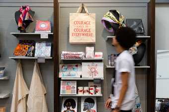 Person walking past a shop display of art merchandise