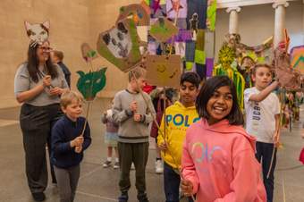 Children smiling and holding decorated cardboard faces