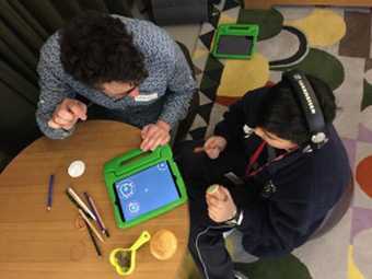 Kids sitting with a tablet at a sound art workshop